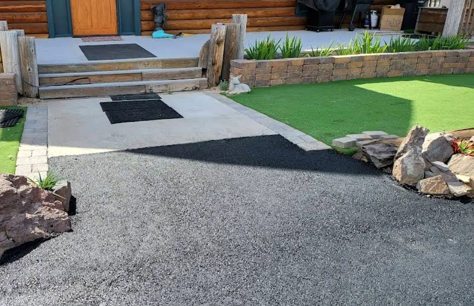 New asphalt approach meeting a walkway at a log home