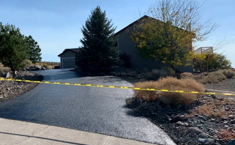 Freshly sealcoated driveway taped off while curing