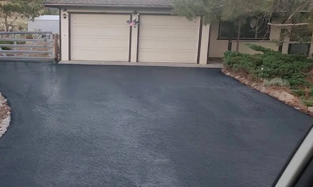 Rich black sealcoated driveway in front of a two-car garage