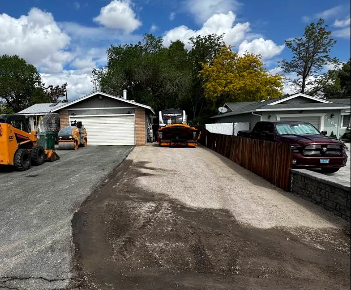 Crew and equipment preparing a residential driveway base