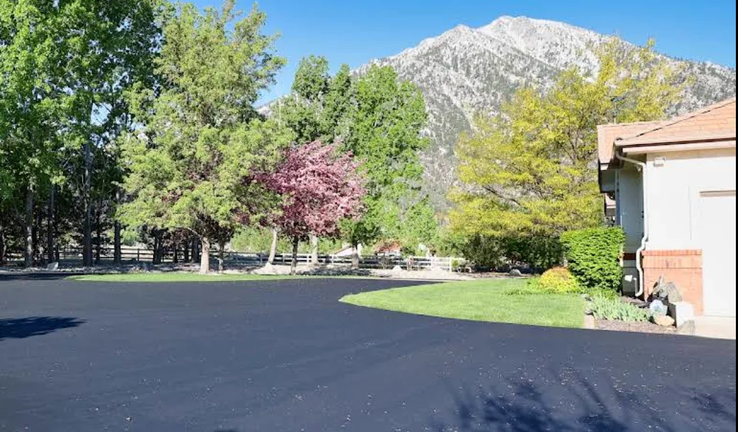Large freshly paved asphalt driveway with a mountain backdrop